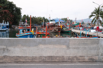 Fototapeta na wymiar Concrete wall. Local fisherman port, fisherman boat mooring. Fisherman village near Pattaya beach, Thailand. ASEAN. South East Asia