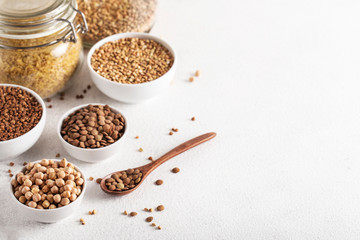 cereals buckwheat chickpeas lentils on a white table side view assorted wooden spoon