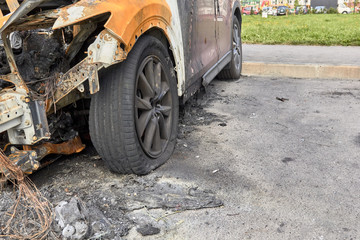 wheels and wheels of a burned-out car in one of the city's districts