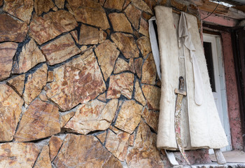 Ancient clothes of a warrior in the mountains. Burka and sword.