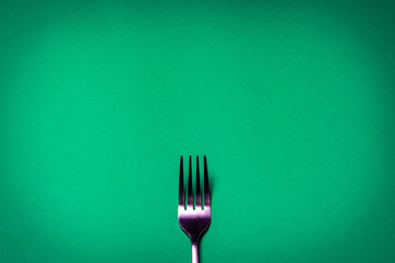 Fork on green background. Backgrounds for food