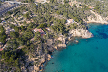 Obraz premium Aerial drone top-down view of calm turquoise water and rocks on the beautiful coast of Spain on the east side