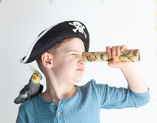 Boy in a pirate hat with a parrot on his shoulder