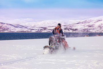 motoslitta nella bufera di neve sulle rive del mare 