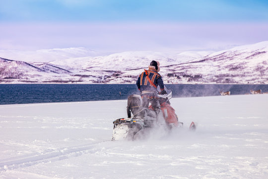 motoslitta nella bufera di neve sulle rive del mare 