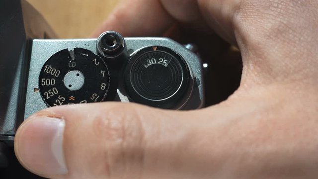 Setting the shutter speed on an analog camera, man's hand