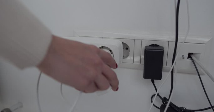 a socket with many things loaded. A girl hand that puts something loaded into the socket.