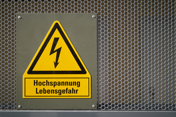  gelbes Schild mit der Aufschrift Hochspannung Lebensgefahr