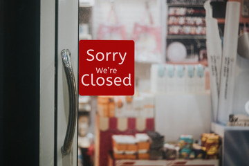 sorry we are closed sign hanging outside a restaurant, store, office or other