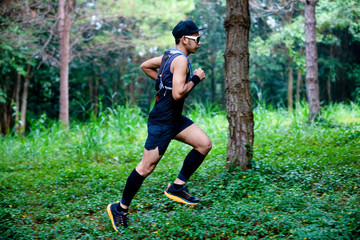 A man Runner of Trail and athlete's feet wearing sports shoes for trail running in the forest