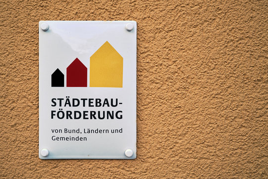Schild an einem sanierten Gebäude mit der Aufschrift Städtebauförderung von Bund, Ländern und Gemeinden.