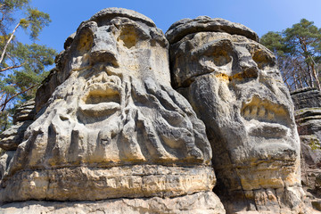 Fototapeta na wymiar Devil's heads, monument sandstone sculptures from 19th century in northern Bohemia, Zelizy, Czech Republic