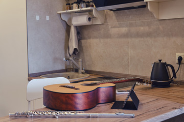 The guitar and flute are on the kitchen table for an online music lesson. Video over the Internet during quarantine due to coronavirus