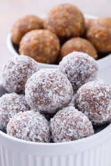 Two types of energy balls - in the foreground balls with dates, almonds, coconut flakes, honey and cocoa