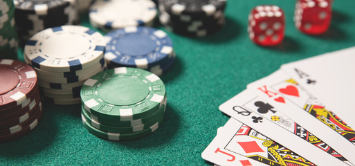 Poker chips, cards on green table