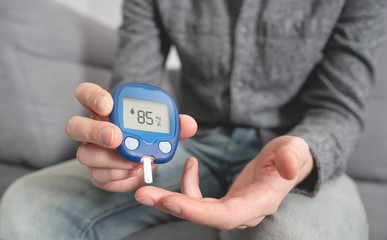 Young man measures blood sugar level