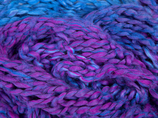 Background image, texture of a large binding. Purple-blue gradient. Wool. Bright yarn color. Hand knitting. Hobbies, learning to knit, schemes for knitting.