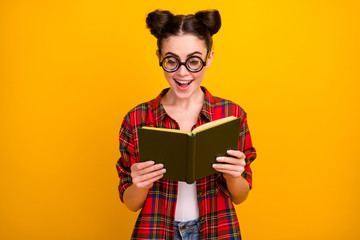 Photo of funny crazy lady hold book read interesting story novel open mouth intrigue moment wear geek vision specs casual checkered shirt isolated yellow color background
