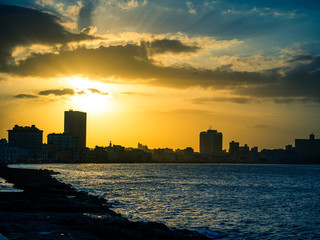 City silhouette in sunset by the sea at the Malecon, Havana, Cuba