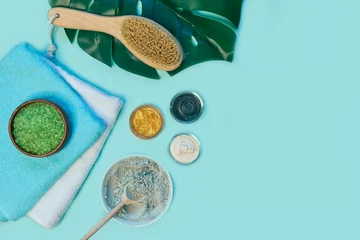 Tuinposter spa massage clay powder, face masks, bath salt, towel, shea butter on blue table background. © yavdat