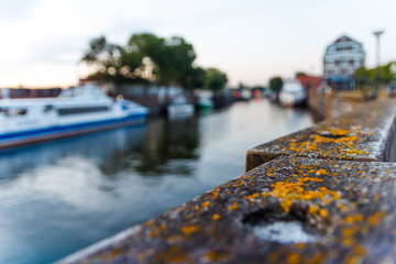 Evening scenery of harbor in empty Lithuanian town. A bay with bench, houses, boats when sun sets.  Calm street with nobody. Seaside evening in Klaipeda. Walking along the sea pier. Old harbor.