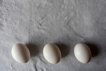 White eggs on paper background, copy space.