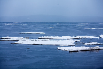Ice floes on the sea. White icebergs in cold water.
