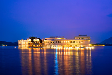 Fototapeta premium Romantic luxury India travel tourism - Lake Palace (Jag Niwas) complex on Lake Pichola in twilight, Udaipur, Rajasthan, India