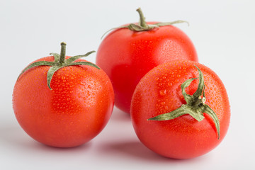 Beautiful juicy red tomatoes on a white background