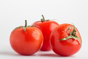 Beautiful juicy red tomatoes on a white background