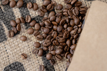 Granos de cafe tostados sin moler arábicas sobre un saco de café a granel