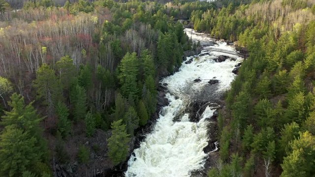 drone shot over onaping falls in sudbury Ontario during spring time when the water level was higher than normal and flowing angry and rapidly