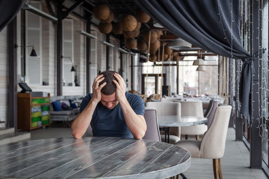 Man restaurant director is holding his head, feel worried and depressed