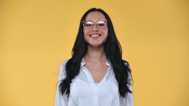 Beautiful businesswoman nodding and showing no at camera isolated on yellow