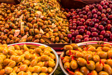 Olives under various marinades on the counter in the market