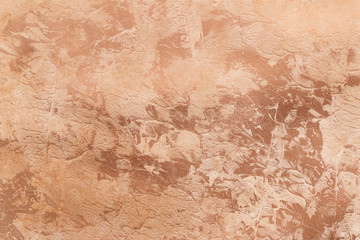 Peachy texture with gold paint leaks and stains. Craft Background.