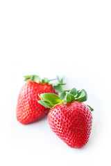 Two fresh strawberries were placed on a white background. Copy space