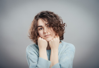 Beautiful sad casual lady isolated on gray background