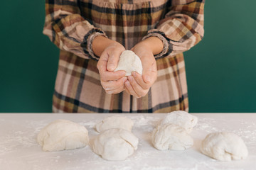 Fototapeta na wymiar Woman prepares to her home handmade pieces of dough for bread, homemade cooking.