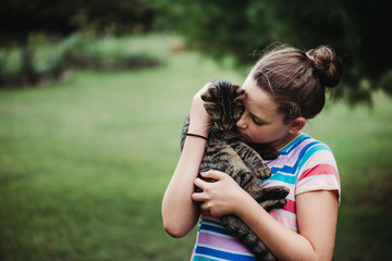 A Girl hugging her cat in her yard