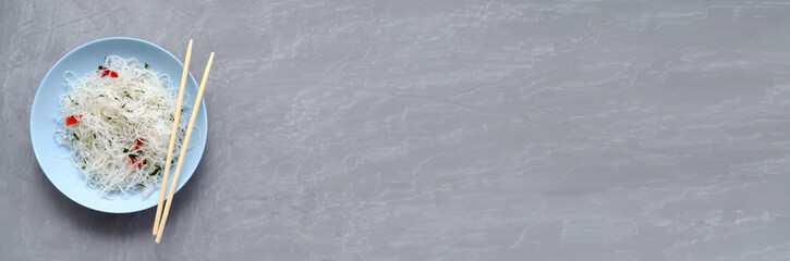 banner with place for text. Fungose glass rice noodles with vegetables, pepper and herbs in a blue...
