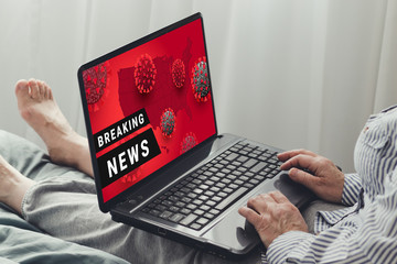 Coronavirus, covid-19 Breaking News. A woman with a laptop is watching the news sitting on a sofa...