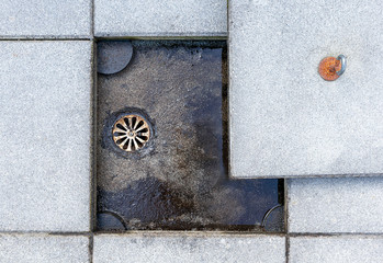 Patio drain cleaning. Rooftop, deck or balcony drain is exposed. The cement tile covering the drain...