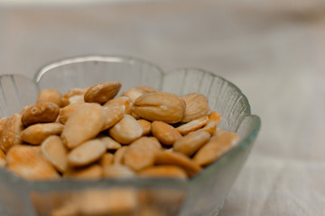 Bowl of  toasted almonds on a gray background