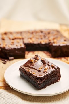 Vertical Shot Of A Piece Of A Fudge Brownie Cake Next To A Bigger One