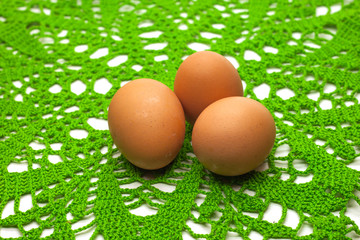 three eggs on a knitted green napkin