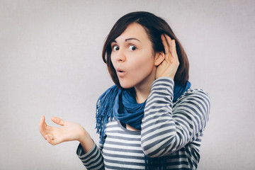 Young woman surprised trying to hearing something