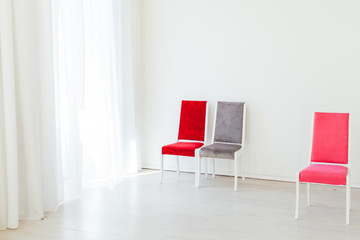 three chairs in the interior of an empty white room