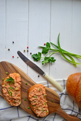 Fish pate with fresh bread on a white kitchen table.