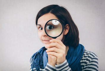 young girl looking through a magnifying glass